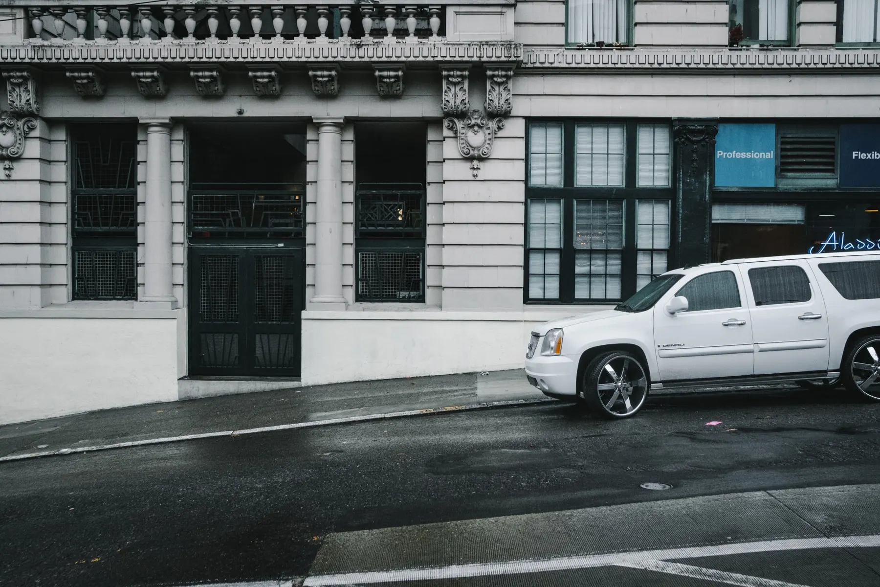 White SUV parked outside an ornate stone facade