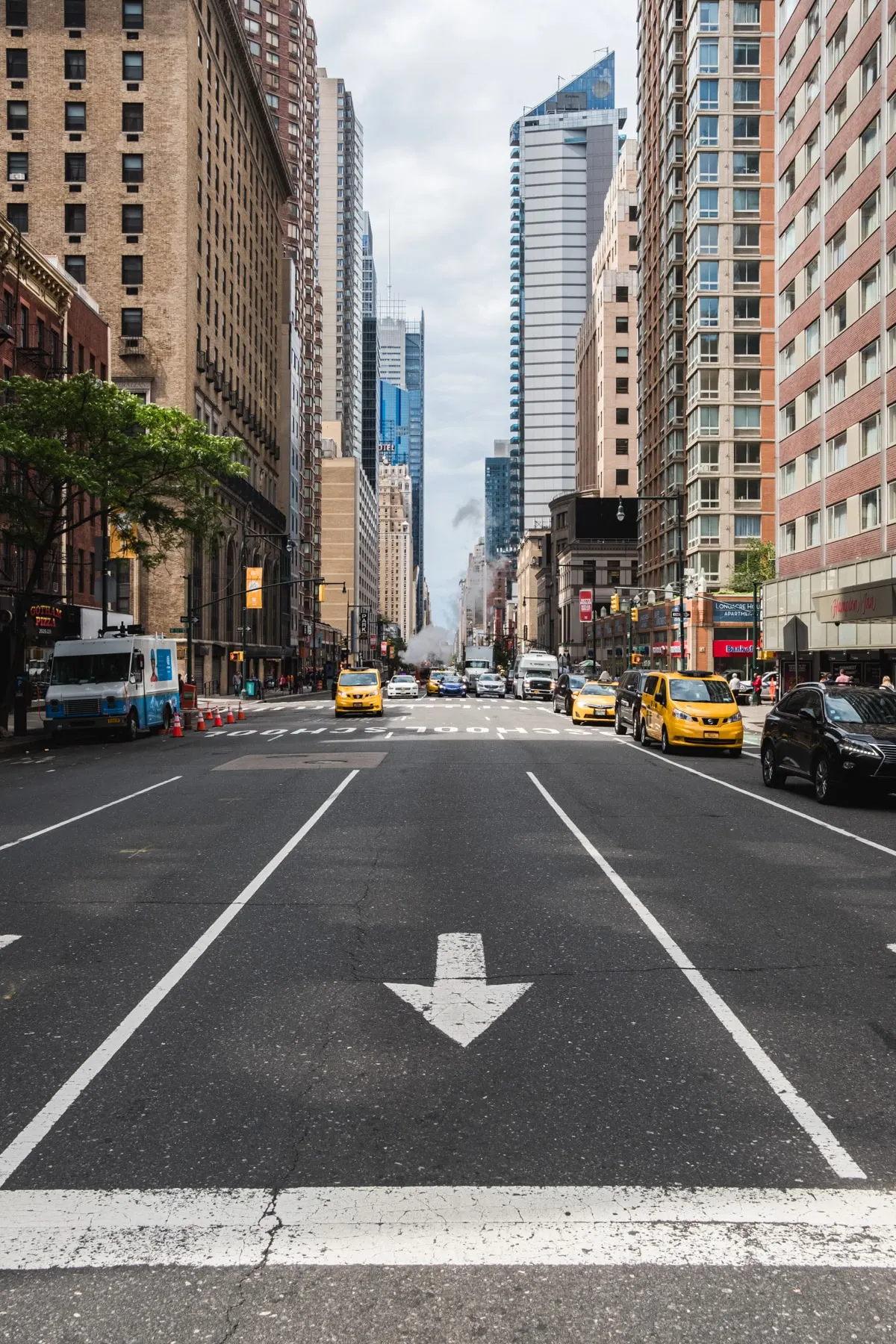 Avenue with taxis under a bright gap between buildings