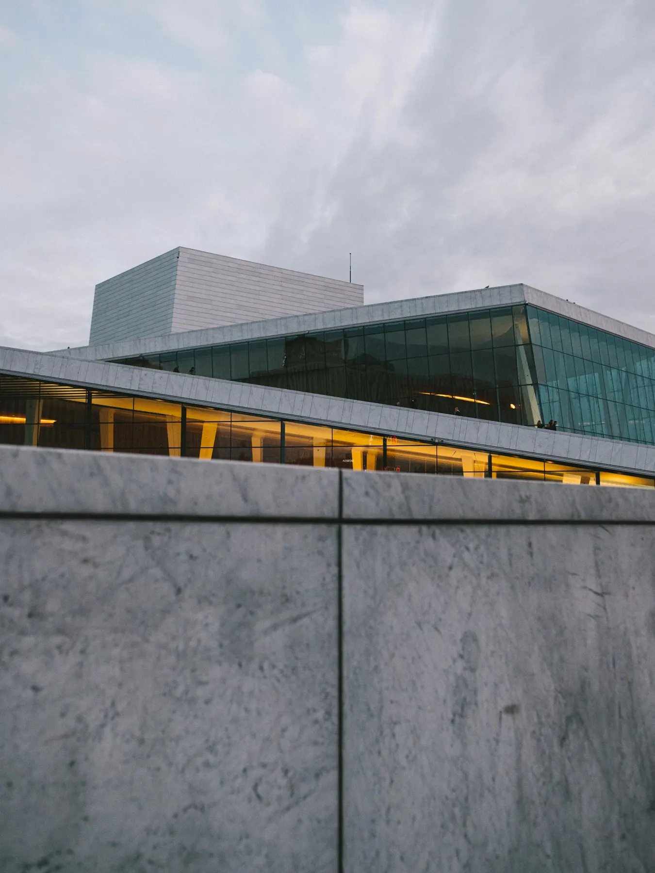 Marble parapet below a glass and stone building