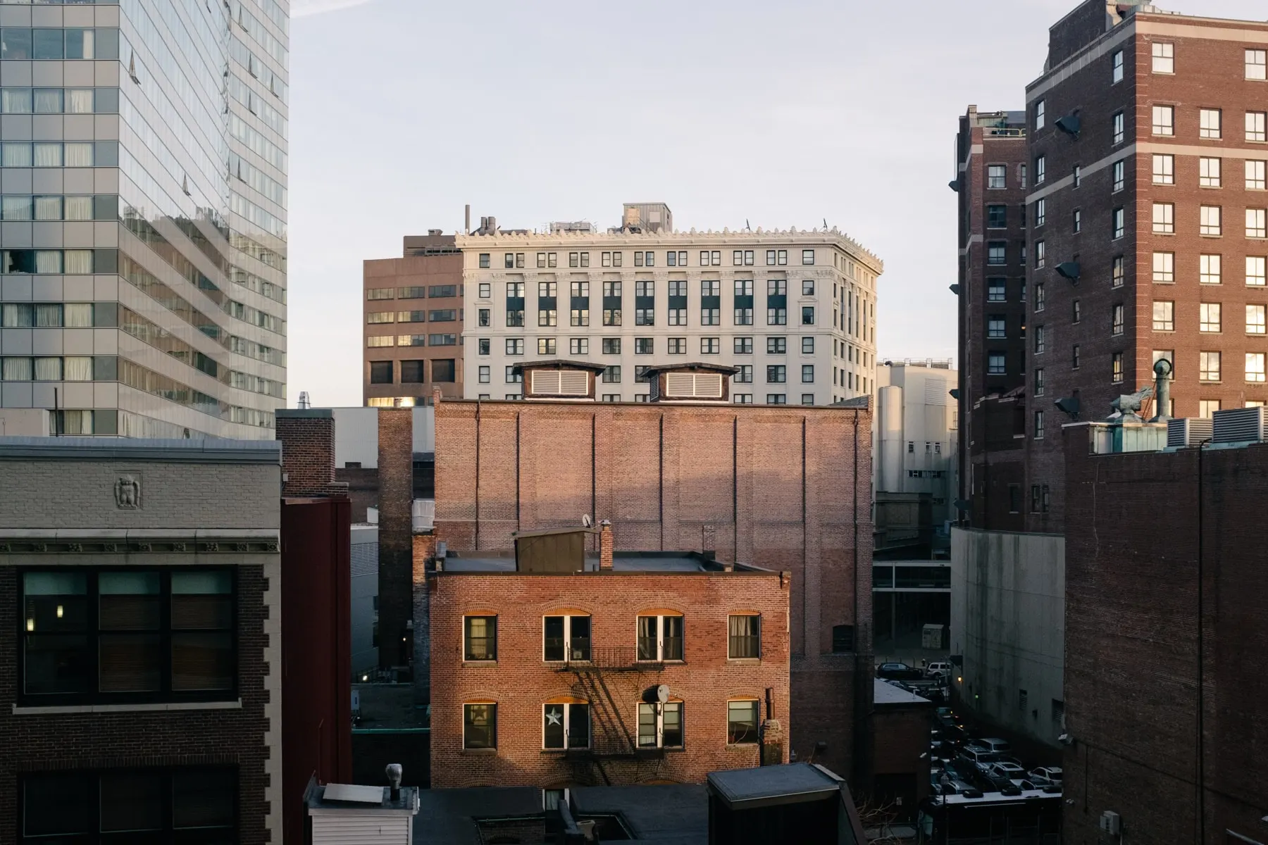 Low brick buildings tucked between taller blocks at dusk