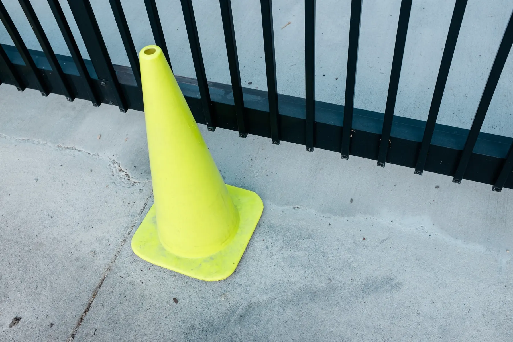 Yellow cone against a black railing