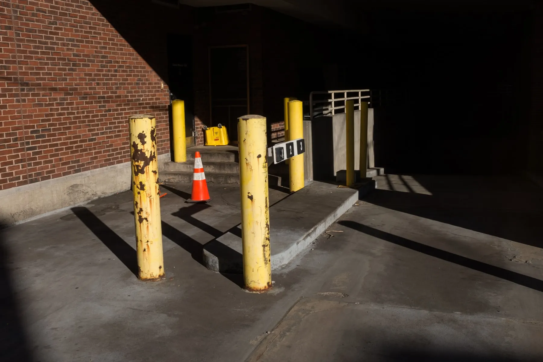 Cone between yellow bollards at a loading bay