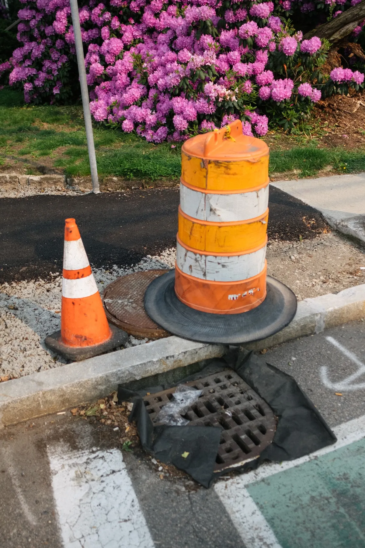 Barrel and cone over a manhole at the roadside